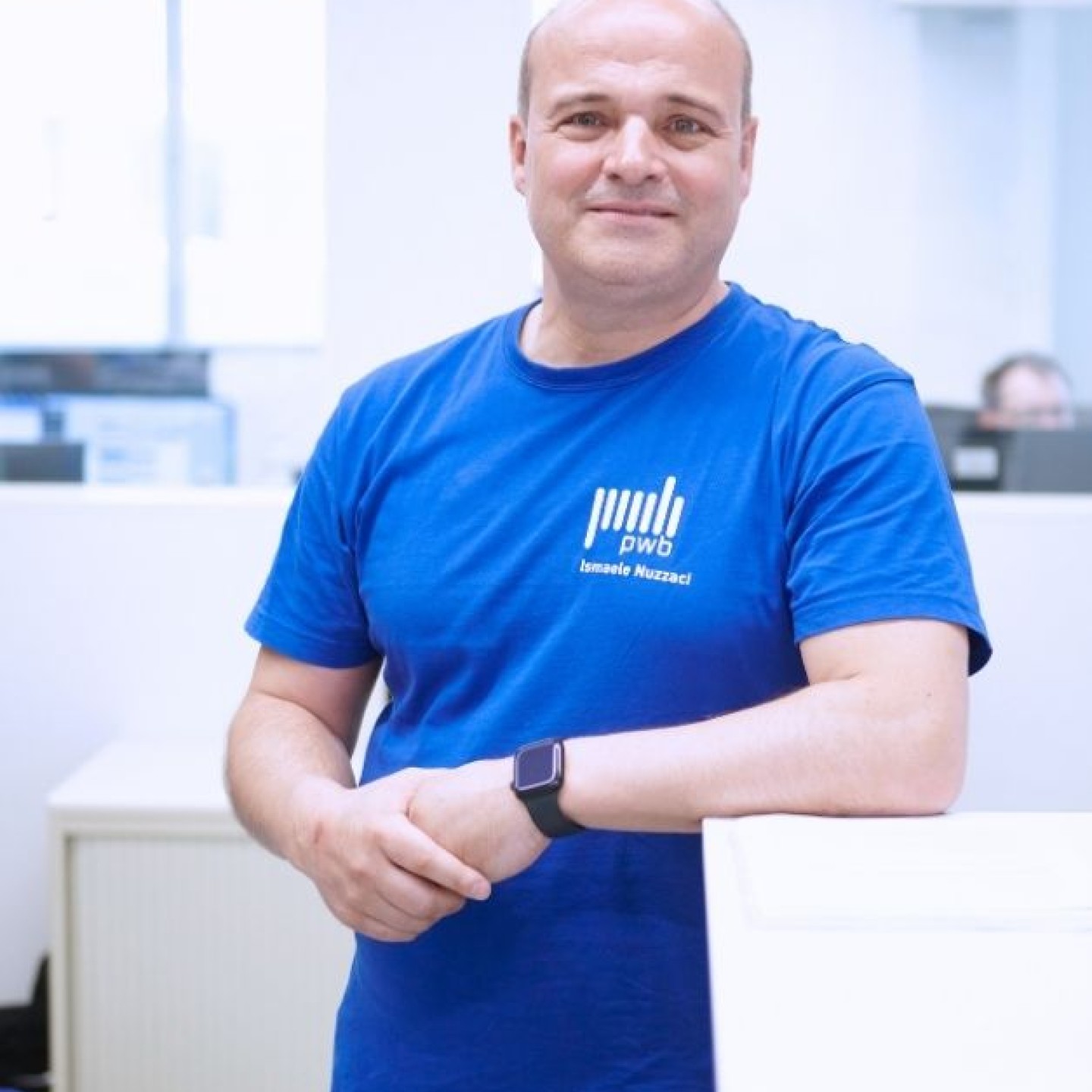 Ismaele Nuzzaci Ausbilder bei PWB AG lehnt in der PWB Academy für mechanische Fertigungstechnik an einem Schreibtisch